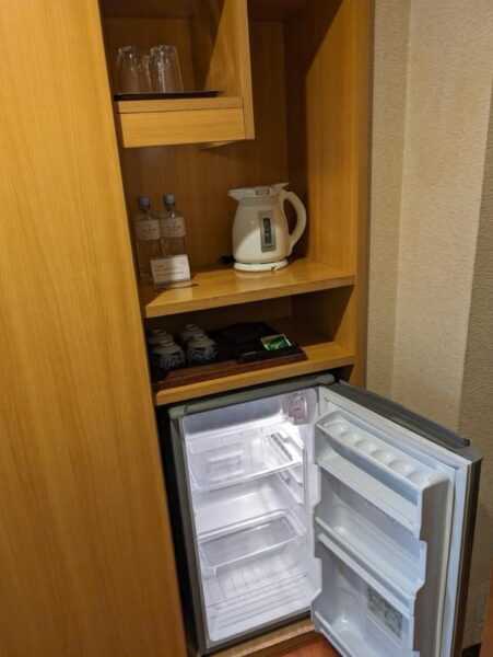 Standard amenities in the room: refrigerator, electric kettle, water, and glasses