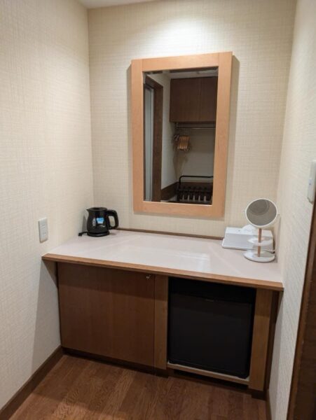 Desk area with mirror and storage for coffee and drinks