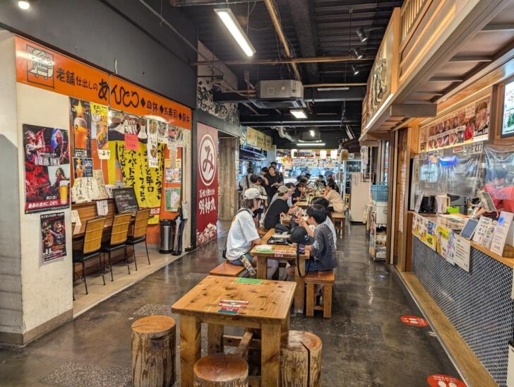 Tables in the center of wider walkways at Hirome Market