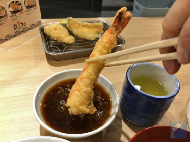 Dipping tempura into radish-infused sauce