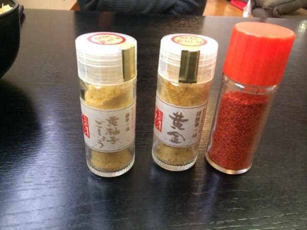 Golden ichimi and yellow yuzu kosho seasonings at the table