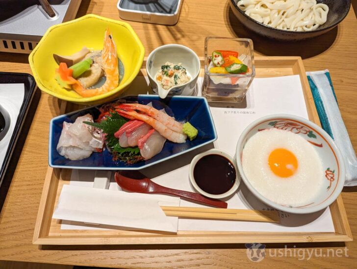 Sashimi, small dishes, and yam with egg for dipping sukiyaki