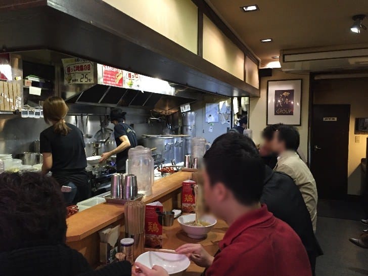 Customers eating at the counter inside Menya Sho