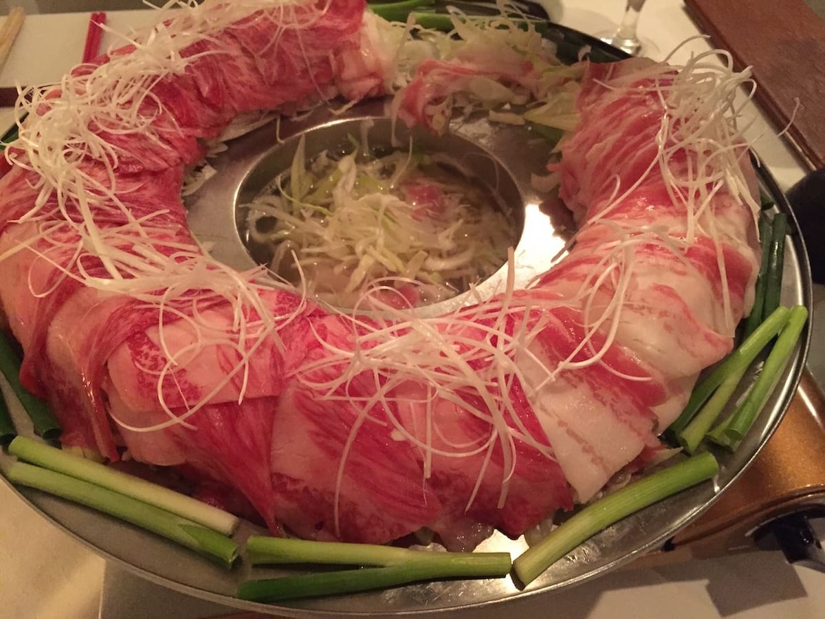 Two-day prepared tail soup bubbling in the center for cooking the meat