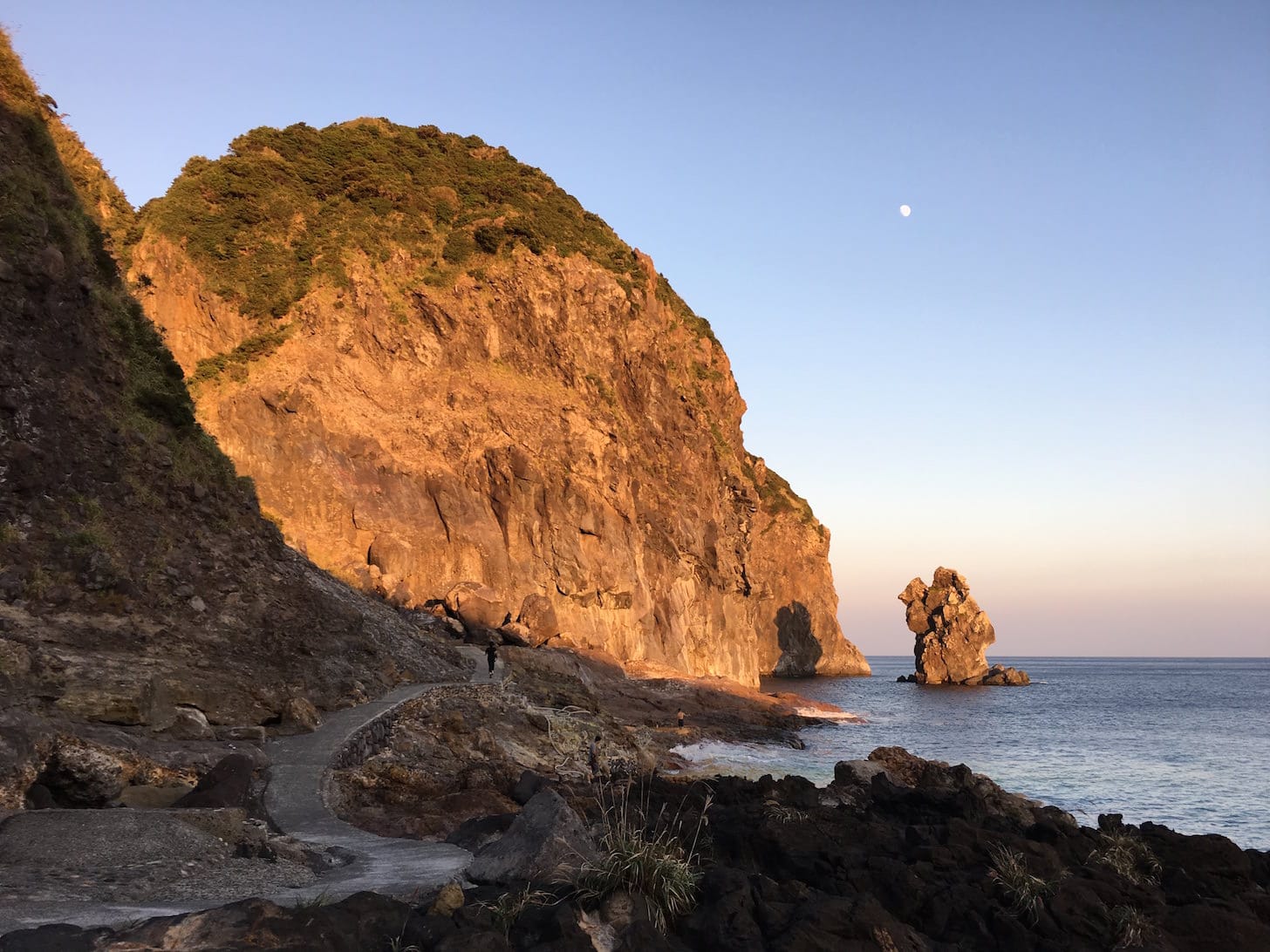 Rocky coastal area at dusk with cliffs and sea view