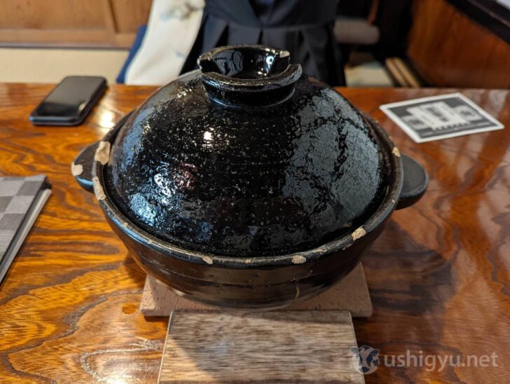 A donabe (earthen pot) of freshly cooked rice is brought out