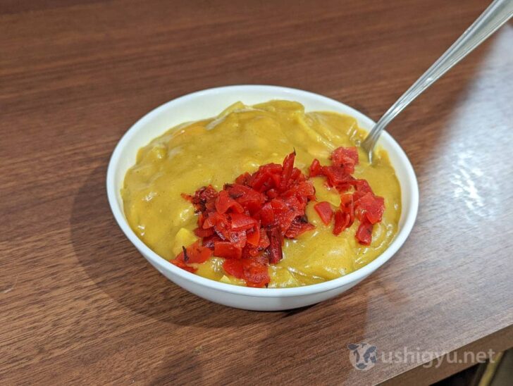 Iconic bright yellow curry with pickles on top