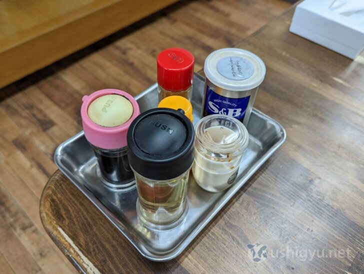 Table condiments include pepper, vinegar, soy sauce, chili flakes, and chili oil