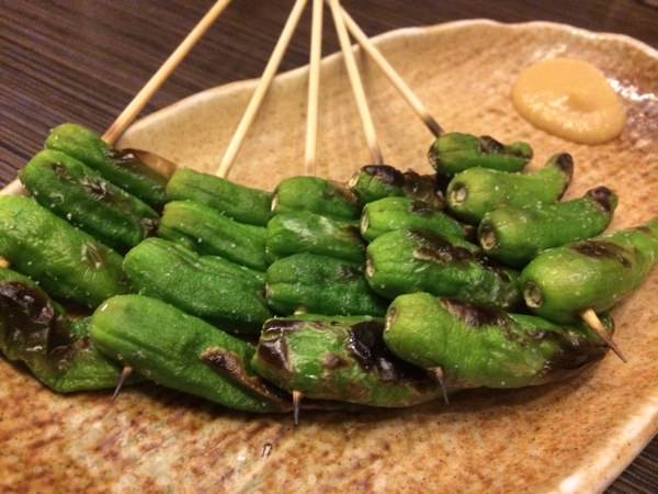 Grilled shishito peppers on skewers