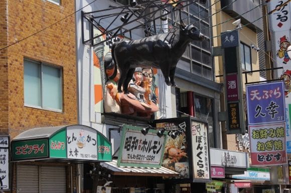 Cow sculpture hanging from storefront
