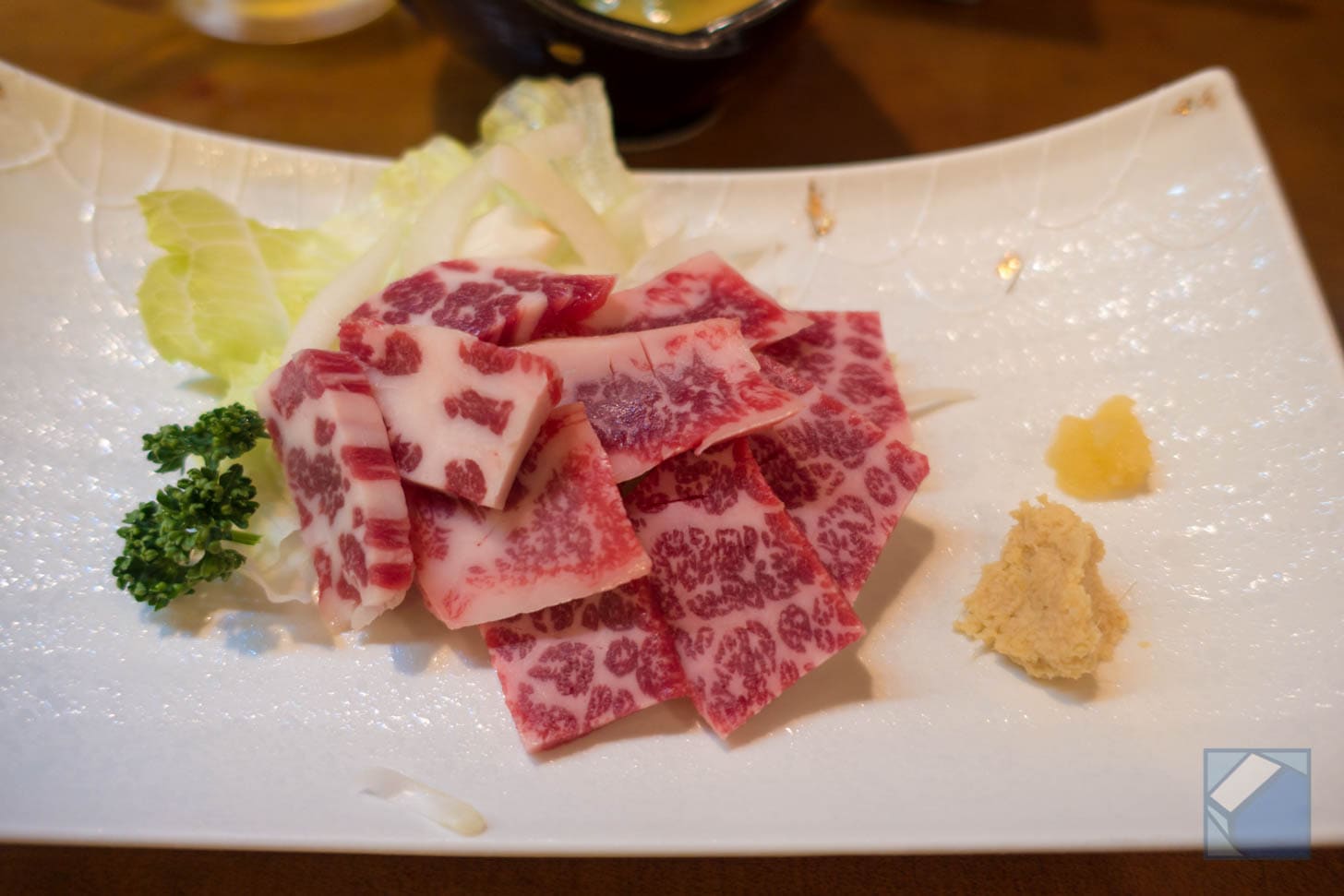 Plate of premium horse sashimi with garnishes
