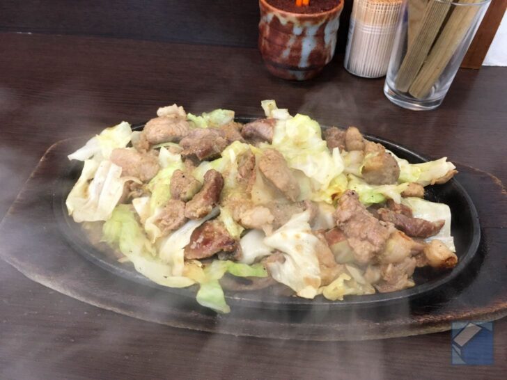 Freshly grilled meat sizzling on plate