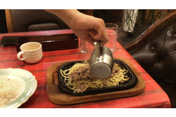 Sizzling sauce being poured over hot plate