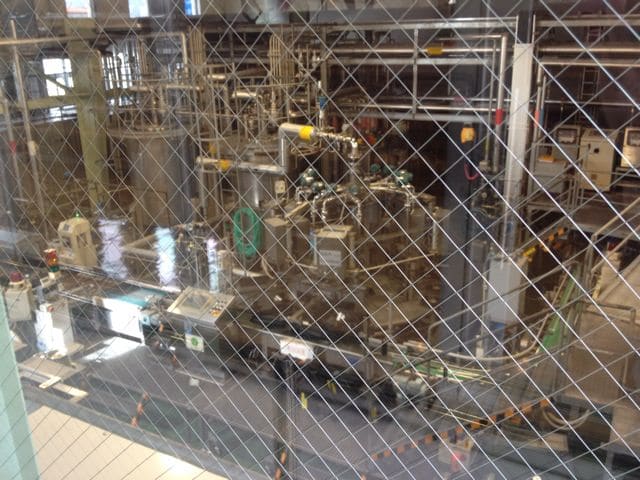 Barrel-filling machinery visible through glass