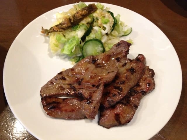 Grilled beef tongue slices on plate